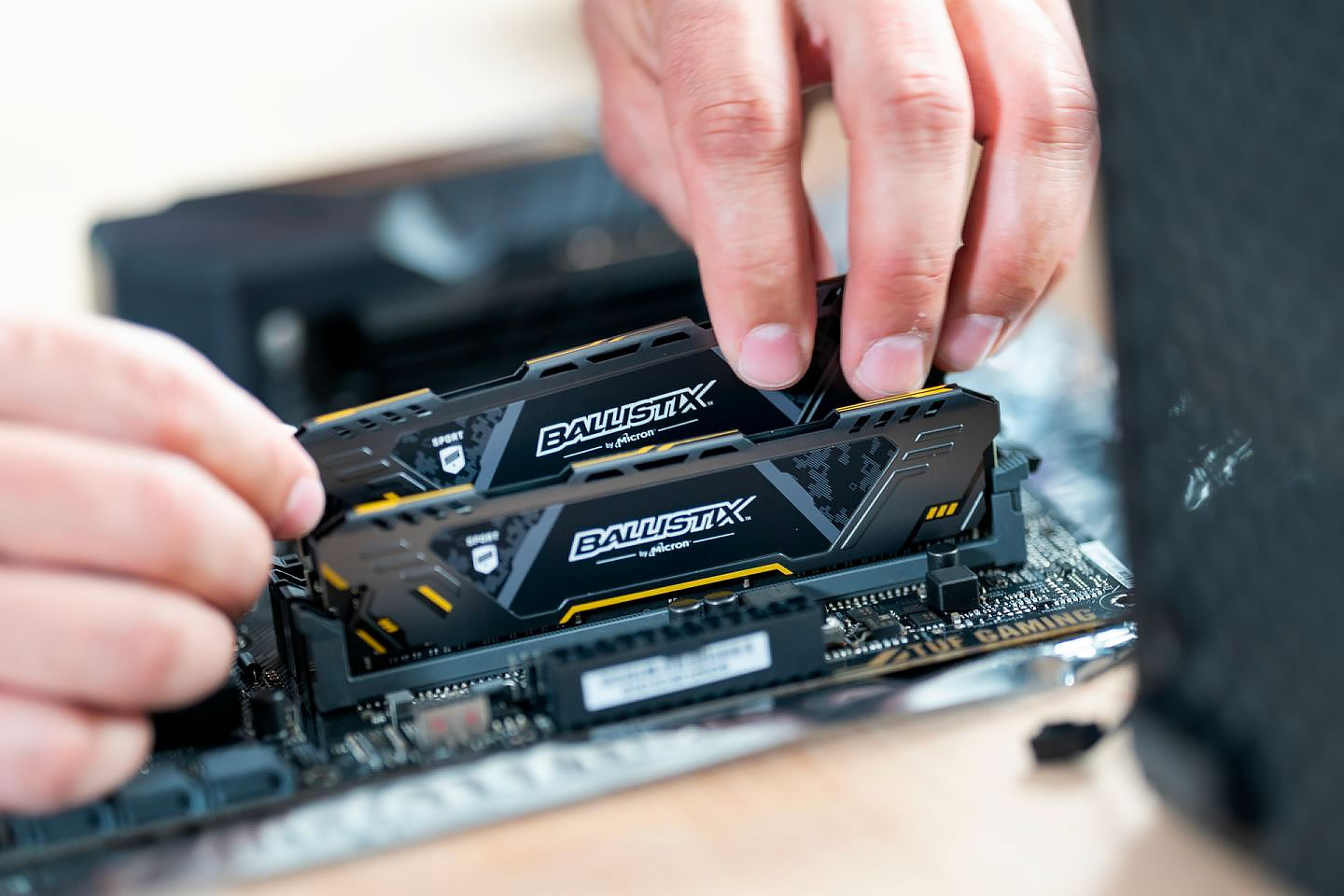 Ballistix memory cards being placed in a motherboard